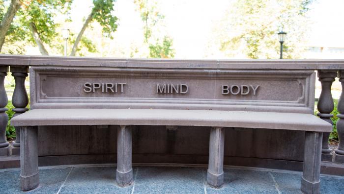 Spirit, Mind, and Body engraved on a bench on campus