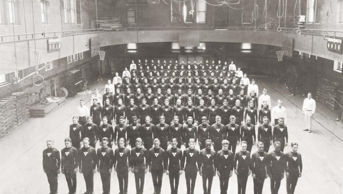 Old photo of YMCA men standing in gymnasium