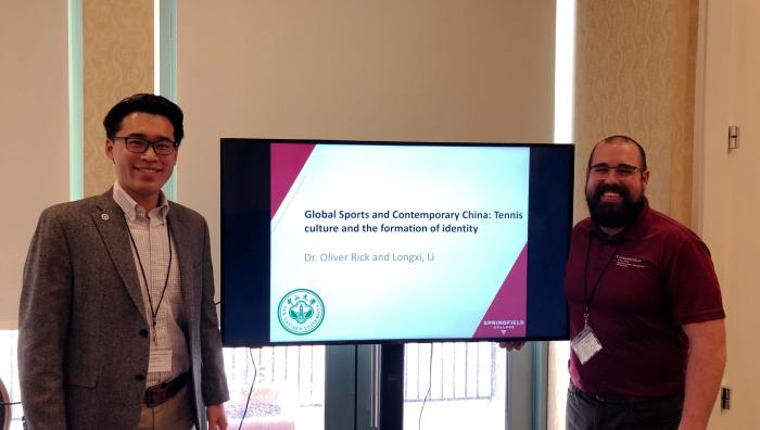 Doctoral student Longxi Li and Dr. Oliver Rick present their research at a conference